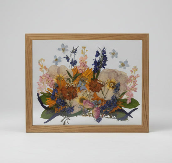 Framed pressed flower art on a wall