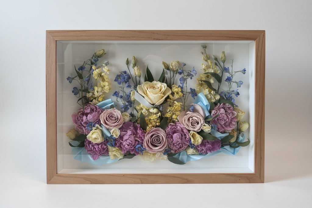 Framed arrangement of dried flowers with a wooden frame