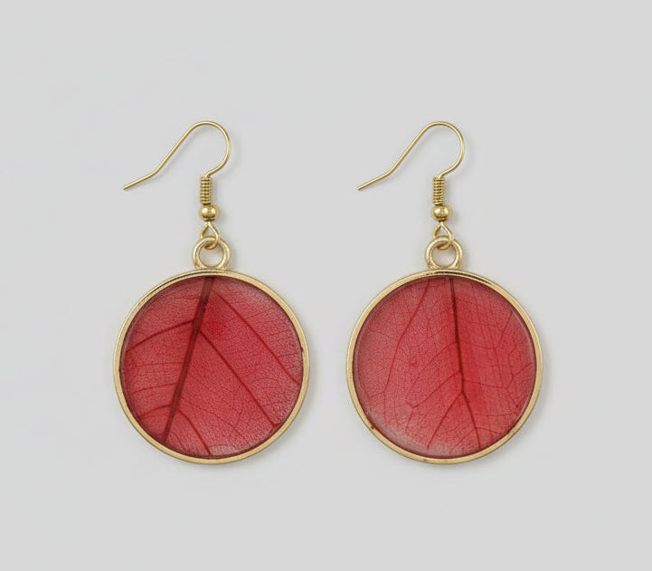 Gold bezel earrings with red maple leaf inside