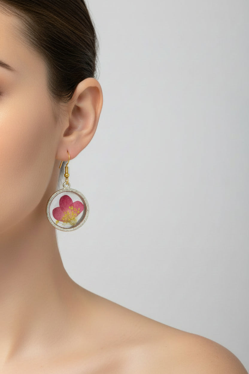 Floral earrings on a cardboard backing against a gray background