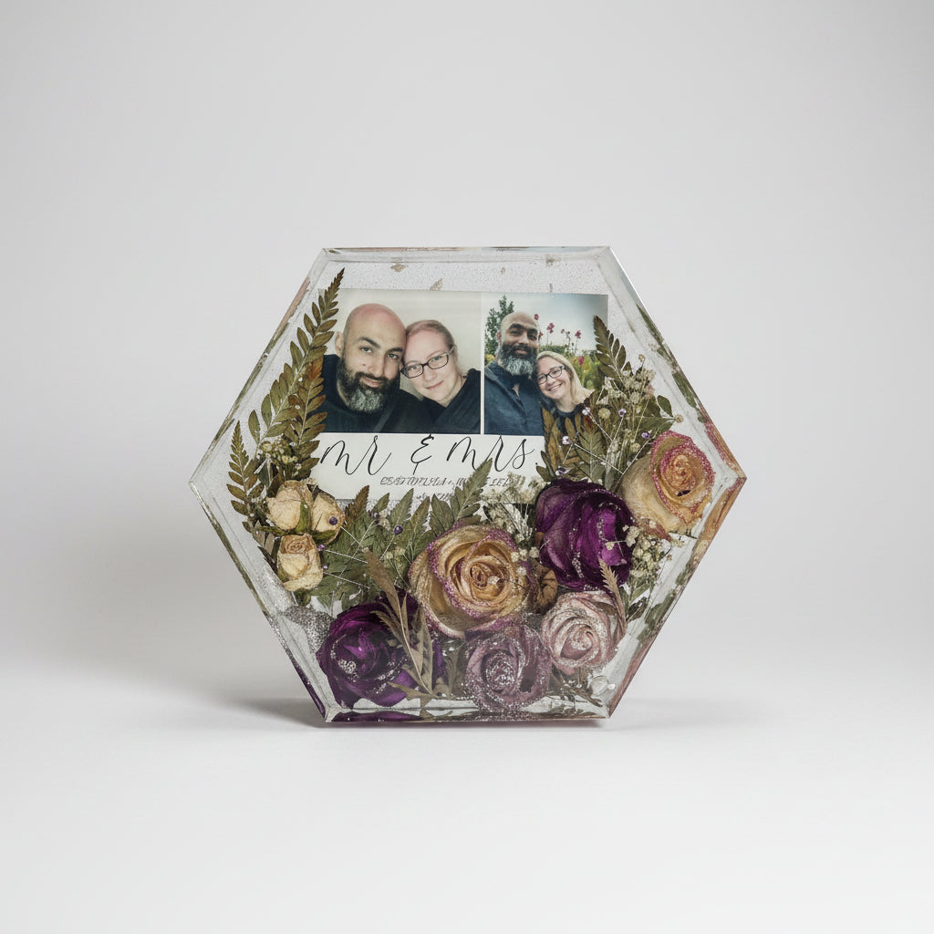 Hexagonal decorative box with dried flowers and family photos on a textured surface