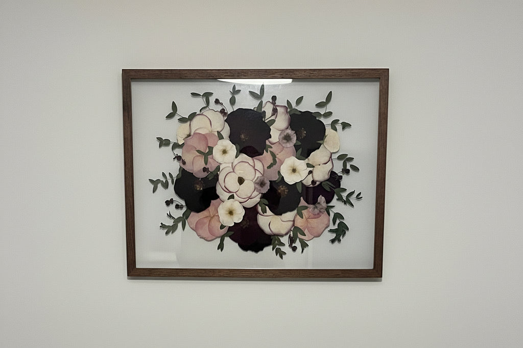 Framed floral artwork on a plain wall