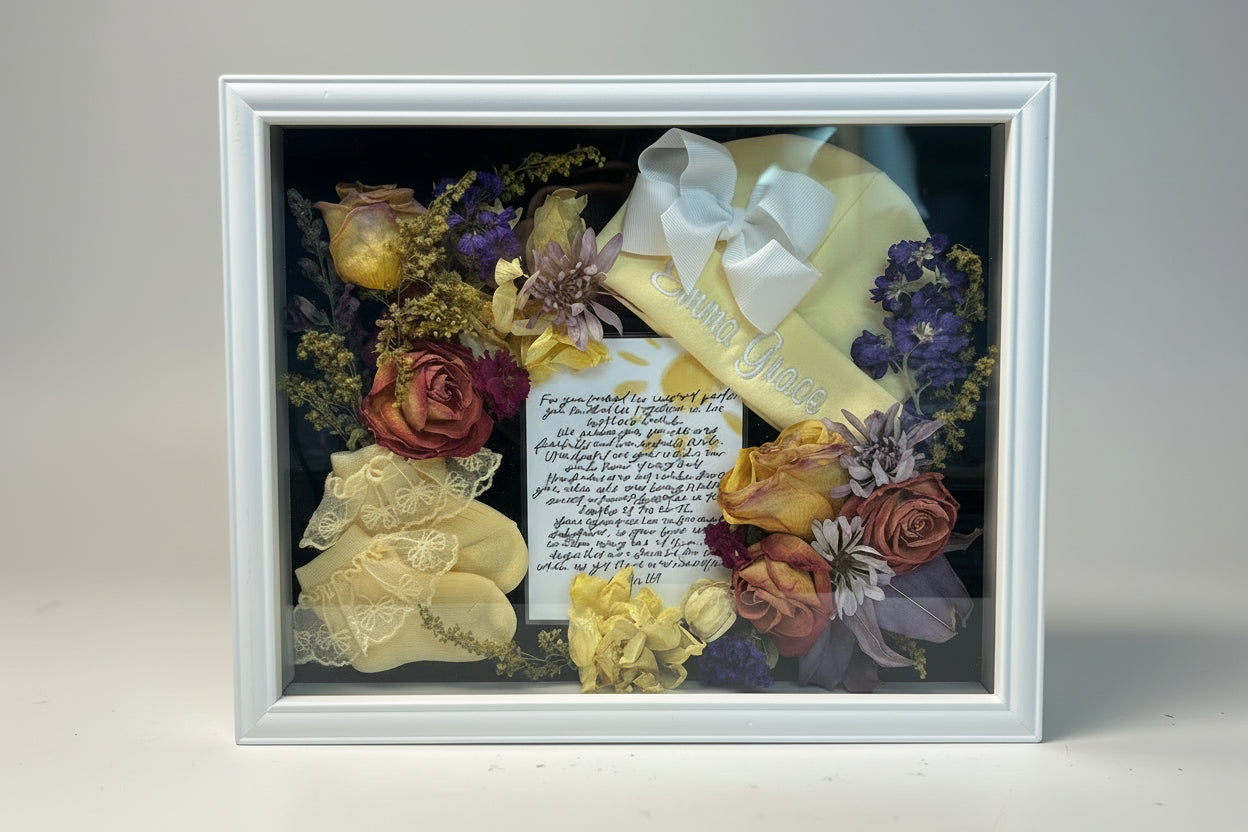 Decorative shadow box with flowers, a yellow hat, and a letter inside.
