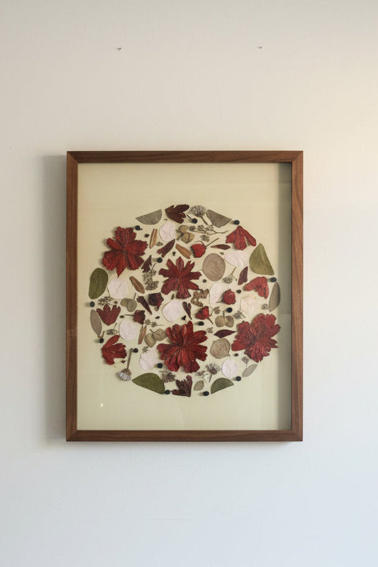 Framed floral artwork on a white wall with a white table in the foreground.