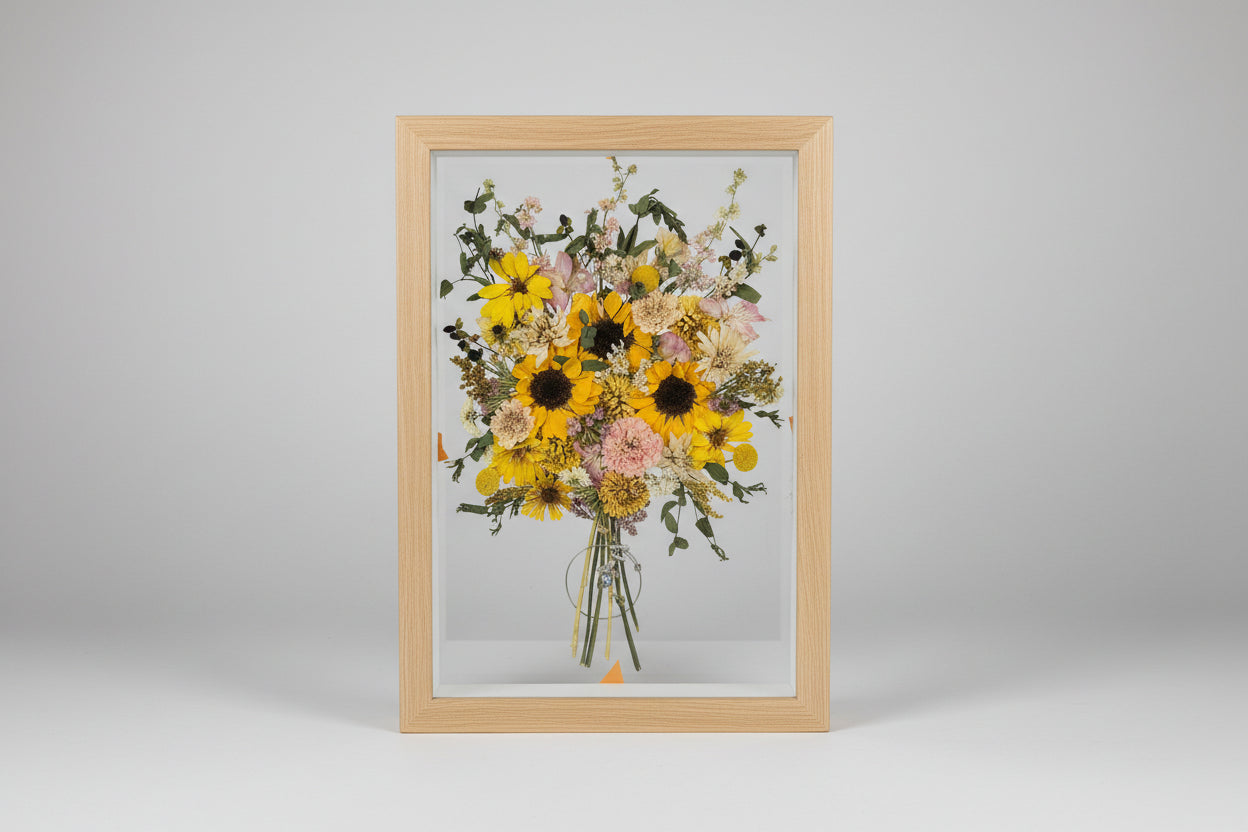 Framed bouquet of dried flowers with a pink background