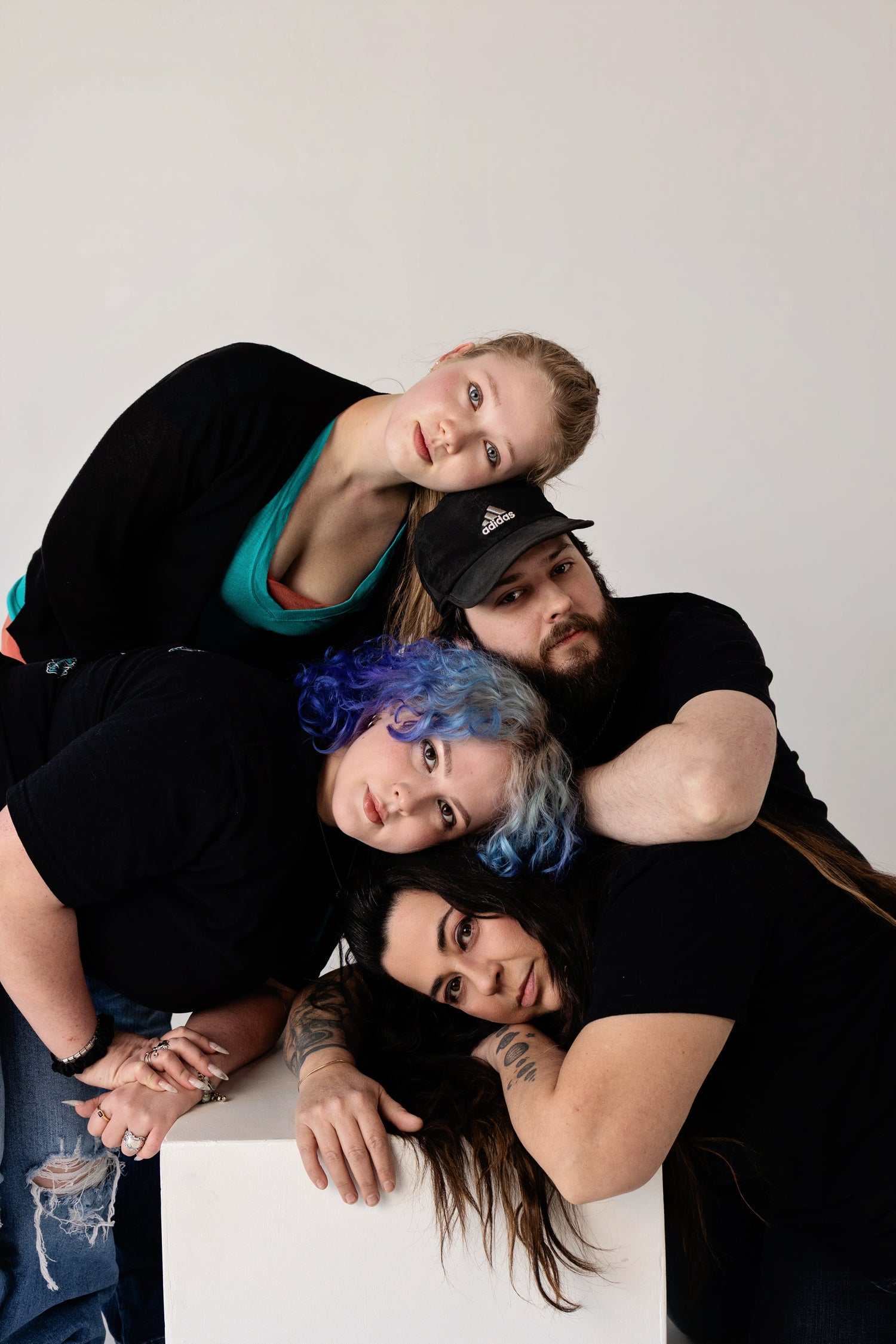 Four people posing together with a plain background