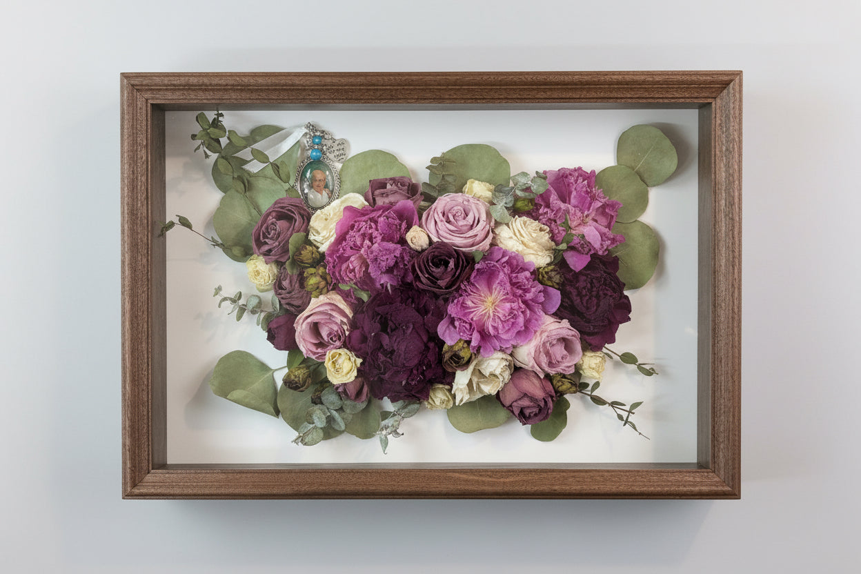 Framed bouquet of pressed flowers with a wooden frame on a white background