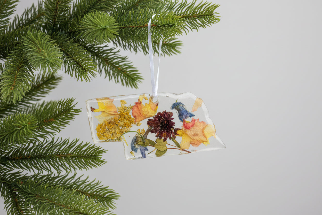 Resin-encased leaf and pine cone pendant on a dark textured surface