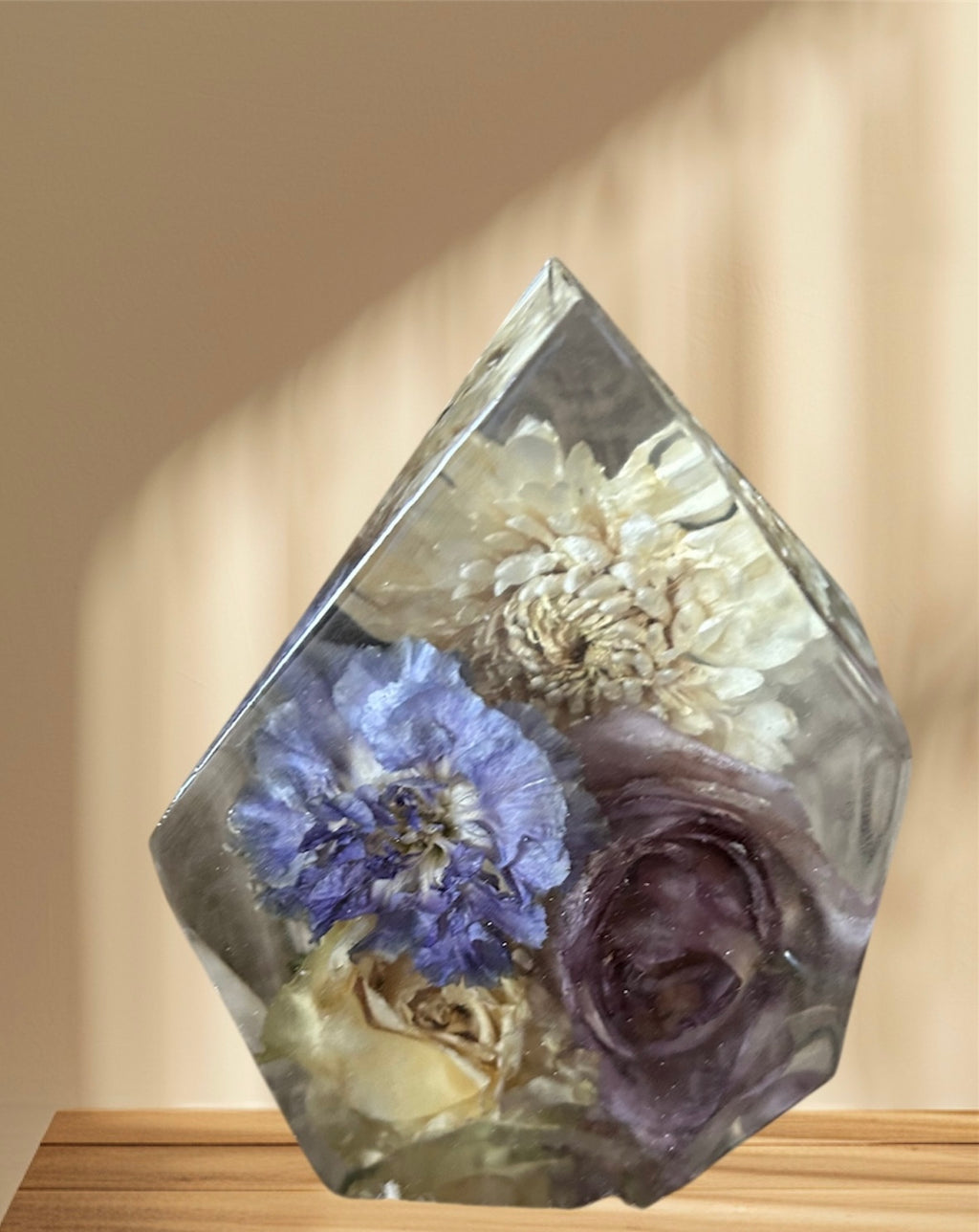Hexagonal crystal with pressed flowers on a wooden surface
