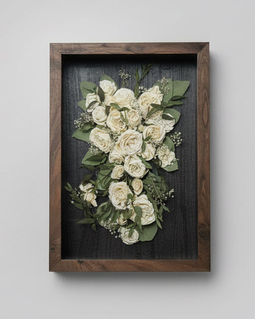 Framed arrangement of white flowers on a gray background