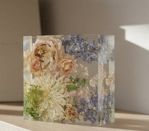 Decorative glass block with floral design on a shelf