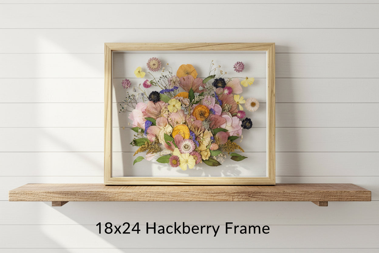 Framed artwork of pressed flowers with a hackberry wood frame on a white background