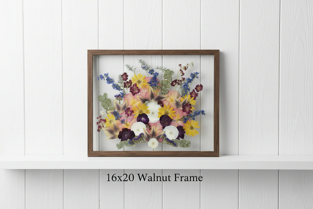 Framed arrangement of dried flowers on a wooden background